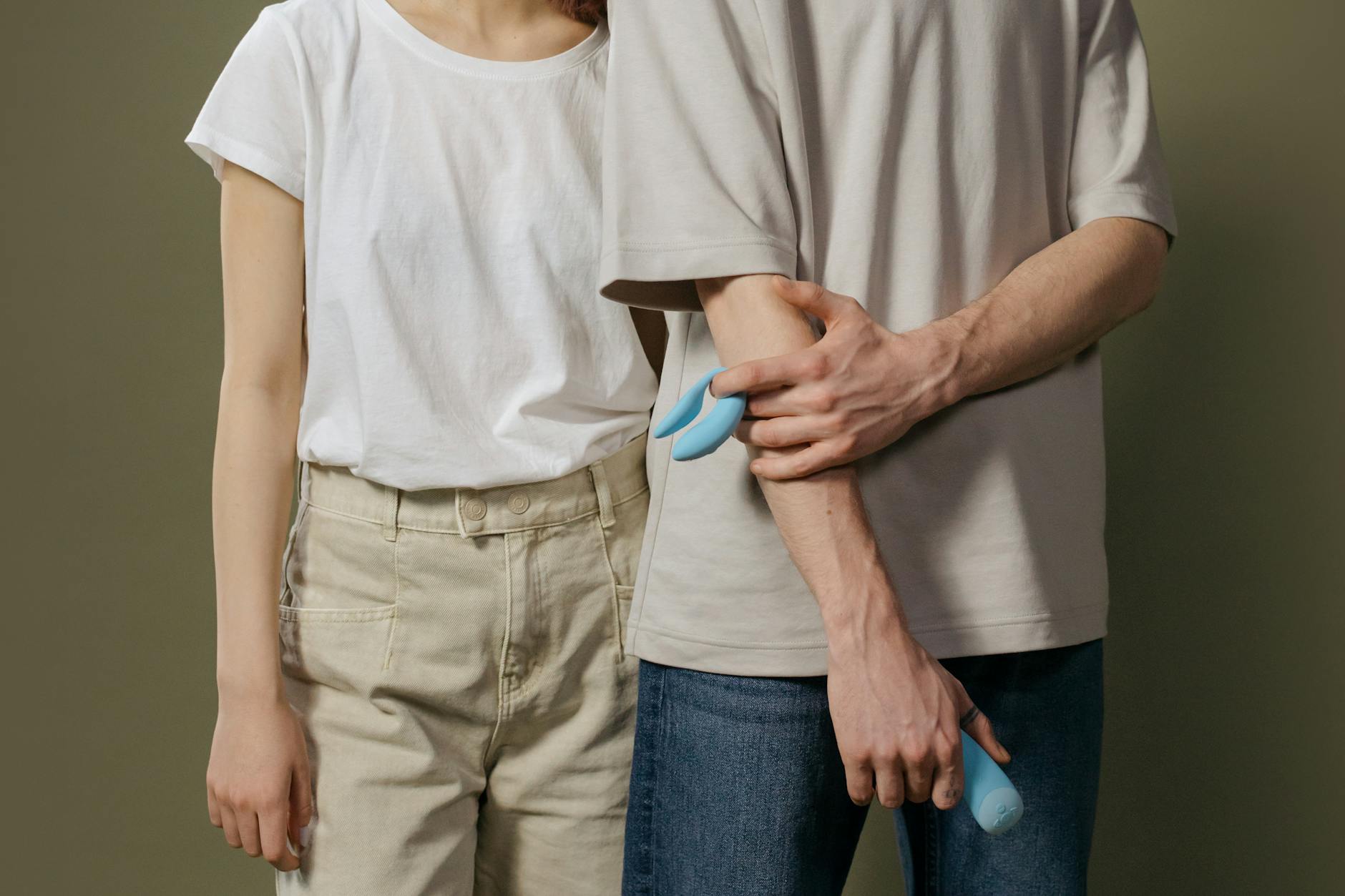 Young couple holding a blue vibrator together, representing modern intimacy and communication